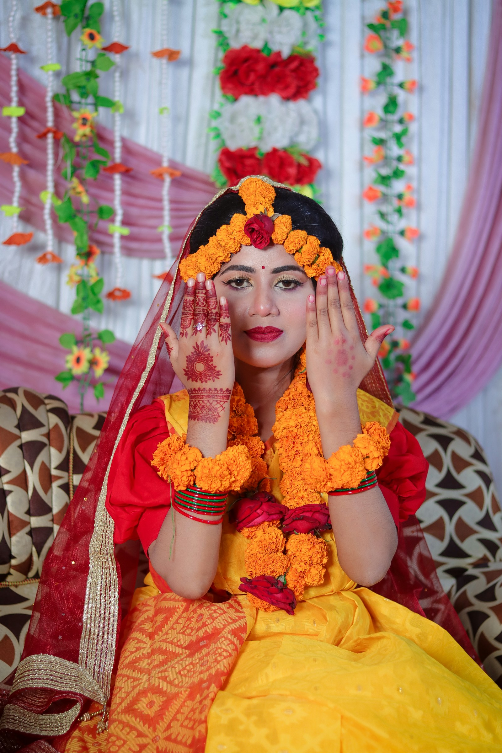Indian bride in yellow saree with marigold floral jewelry at a Haldi ceremony